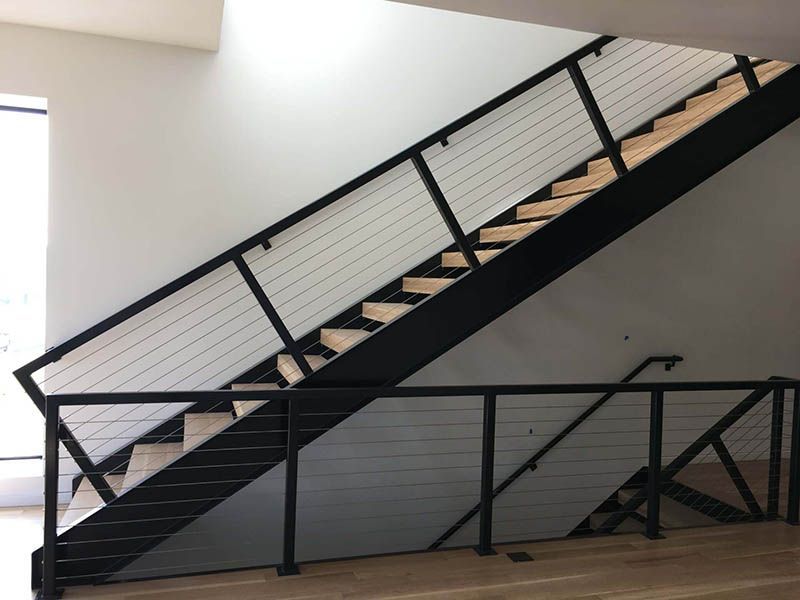 A staircase with a black railing and wooden steps