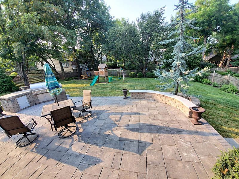 There is a patio with a table and chairs in the backyard.