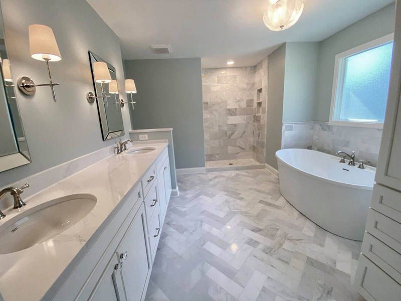 A bathroom with two sinks , a tub and a shower.