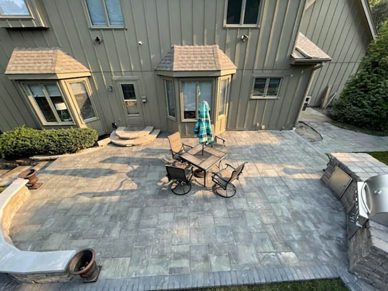 An aerial view of a patio with a table and chairs in front of a house.