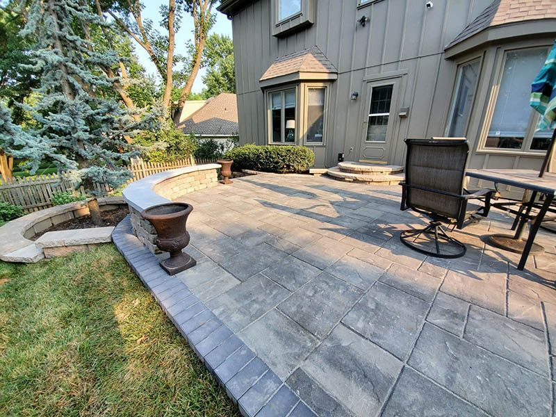 A patio with a table and chairs in front of a house.