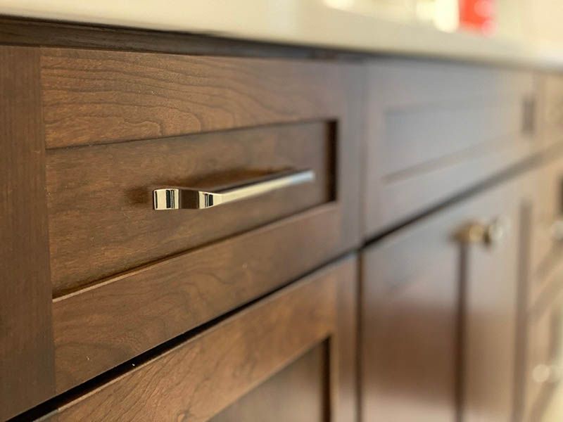 A close up of a wooden cabinet with a metal handle.