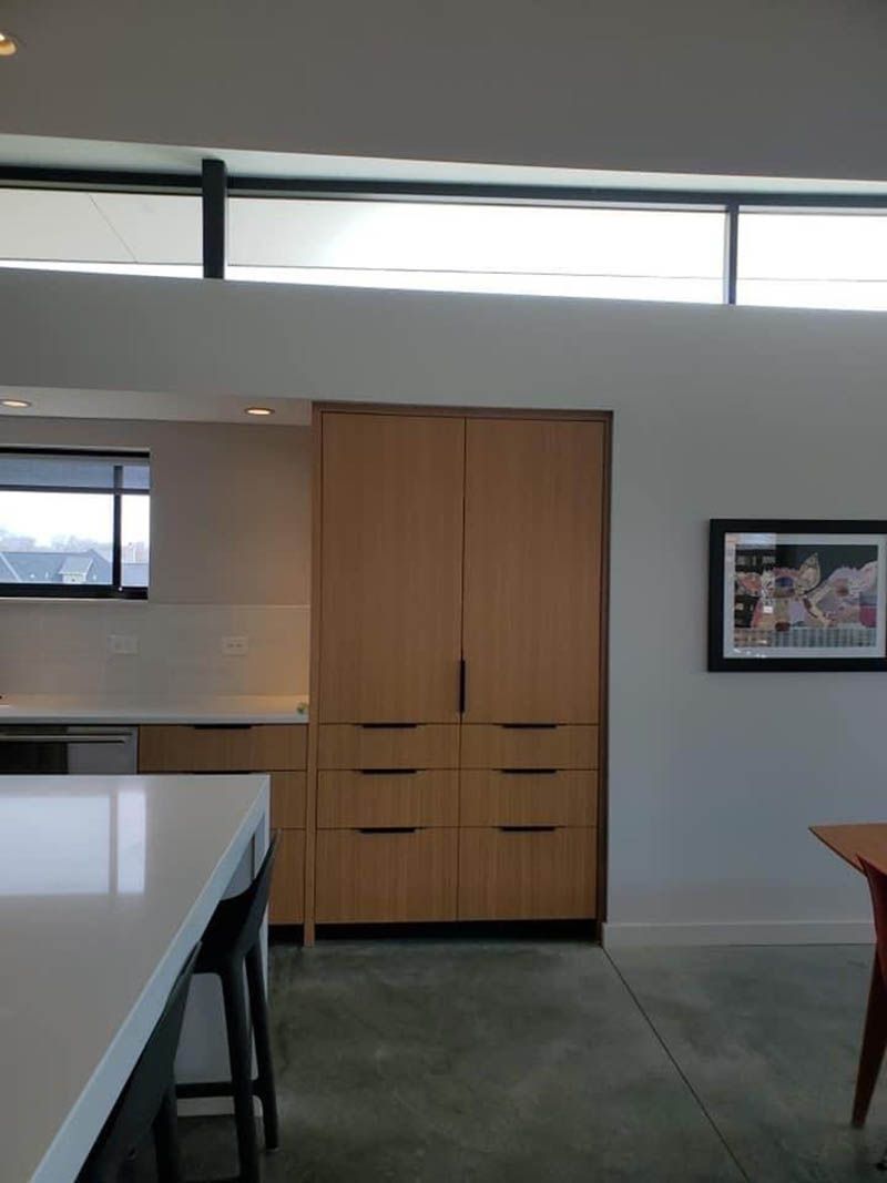 A kitchen with wooden cabinets and a picture on the wall