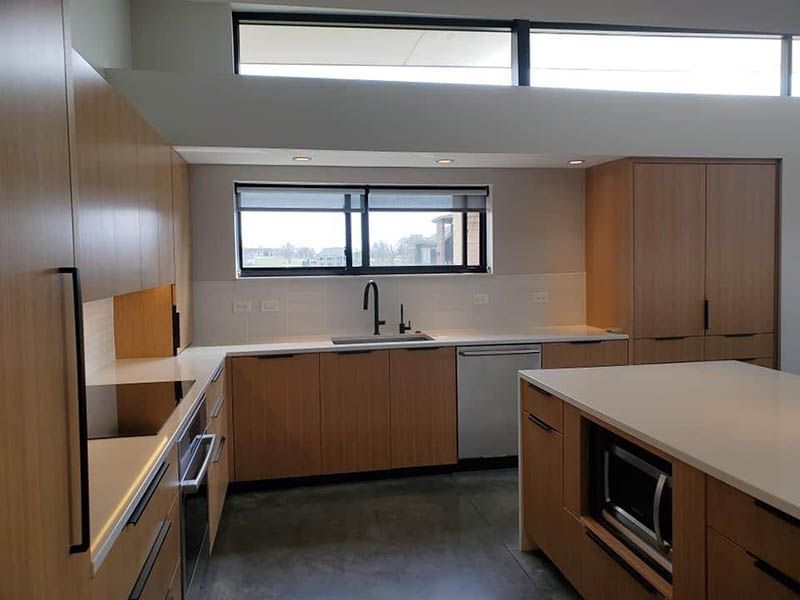 A kitchen with wooden cabinets and white counter tops