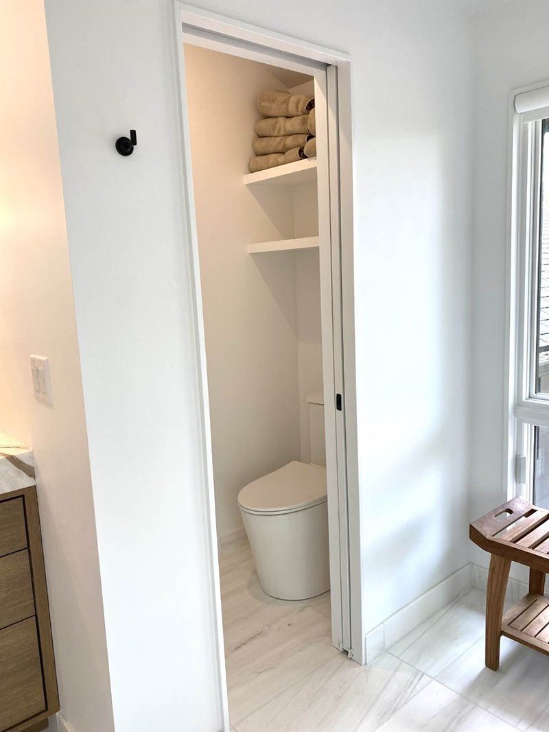 A bathroom with a toilet and a wooden bench.
