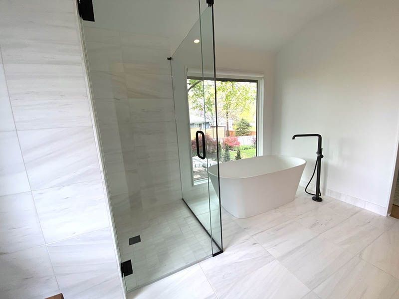 A bathroom with a bathtub and a shower stall.