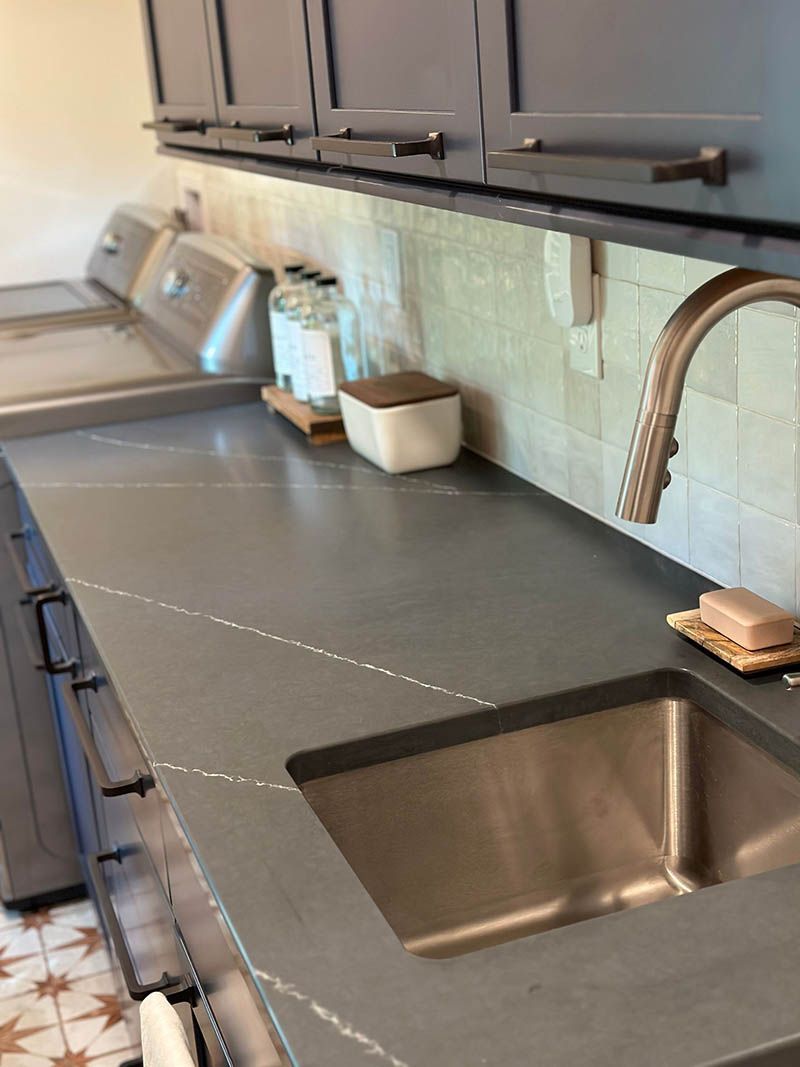 A kitchen counter with a sink and a faucet