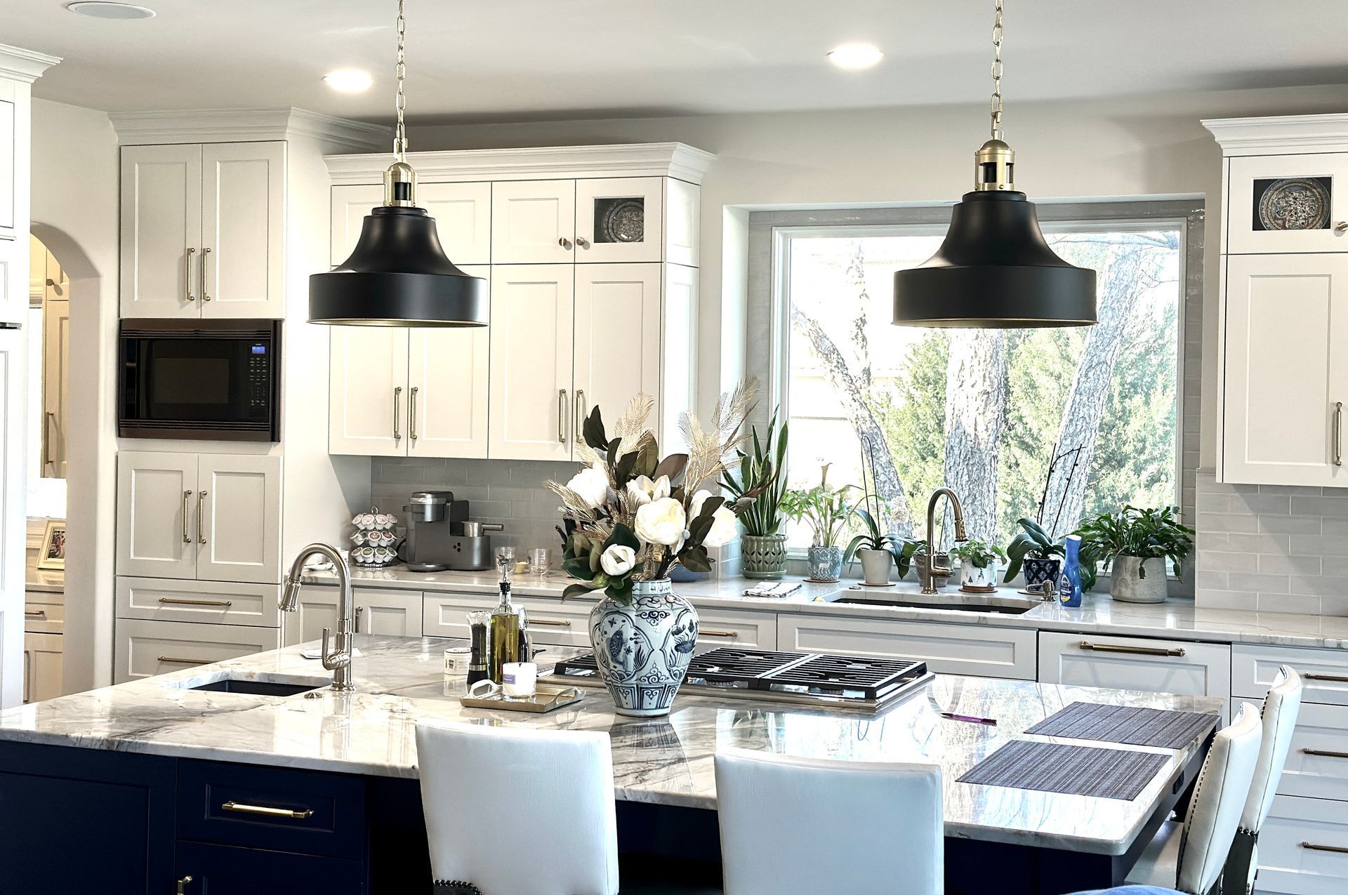 A kitchen with white cabinets and blue cabinets and a large island.