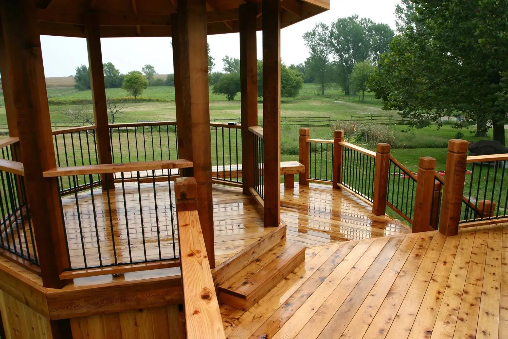 A wooden deck with a gazebo in the background