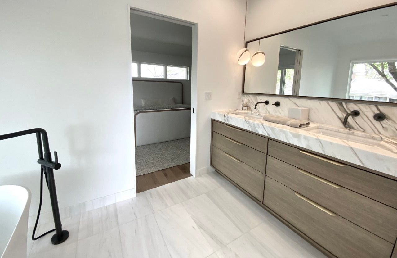 A bathroom with two sinks and a large mirror.