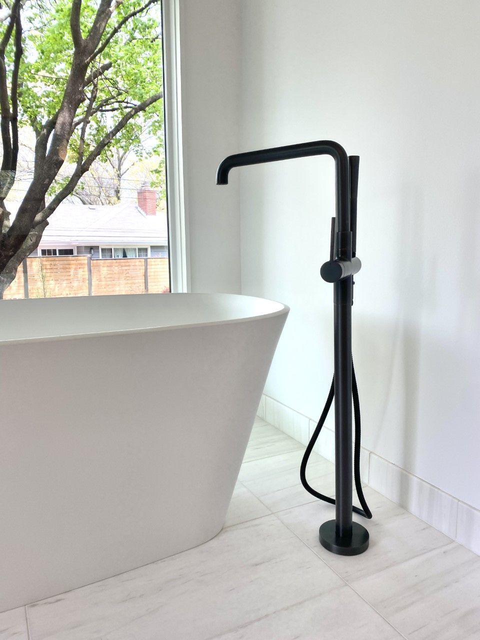 A bathroom with a bathtub and a black faucet.