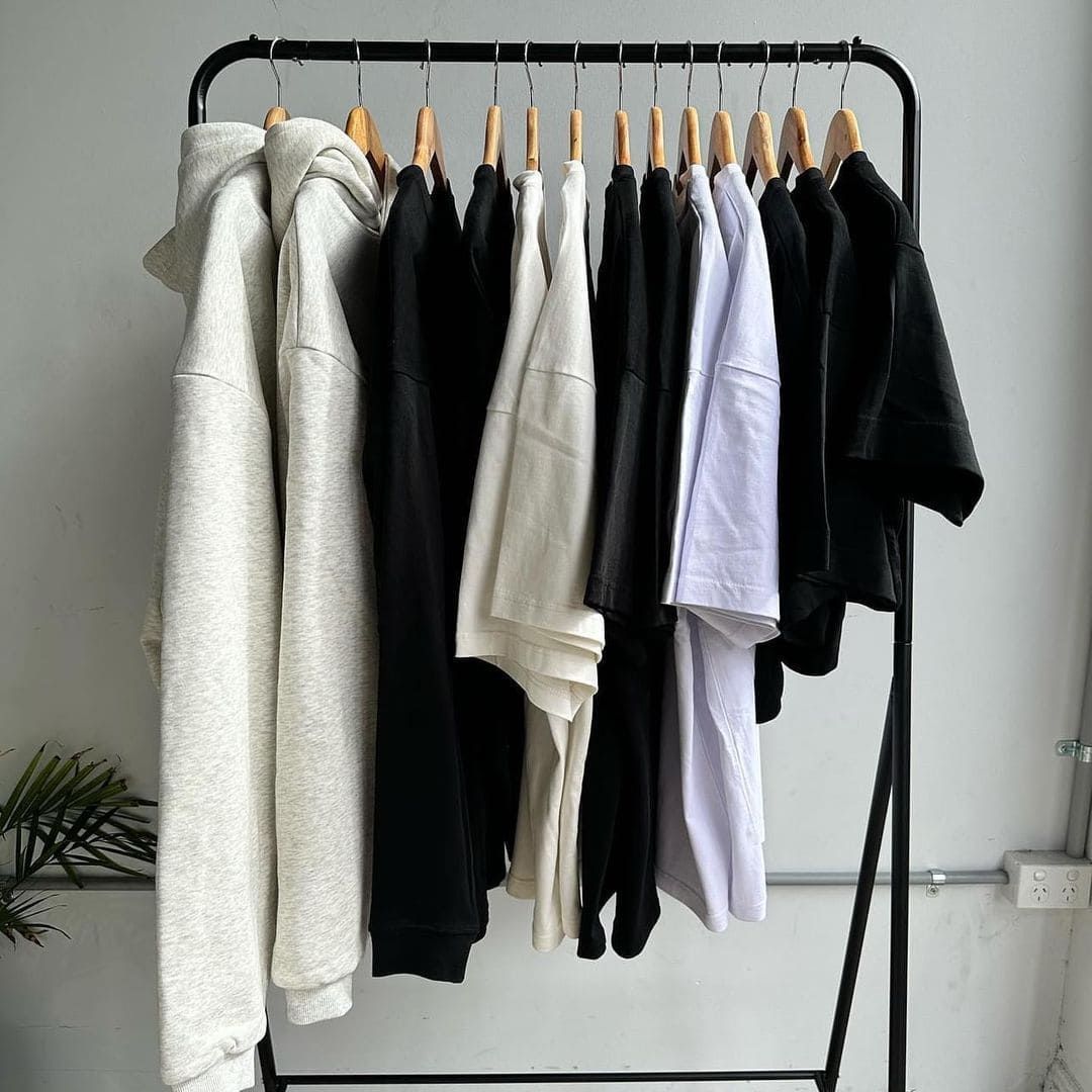 A Rack Filled With Clothes Hanging On Wooden Hangers — Carnival Clothing In Miami, QLD