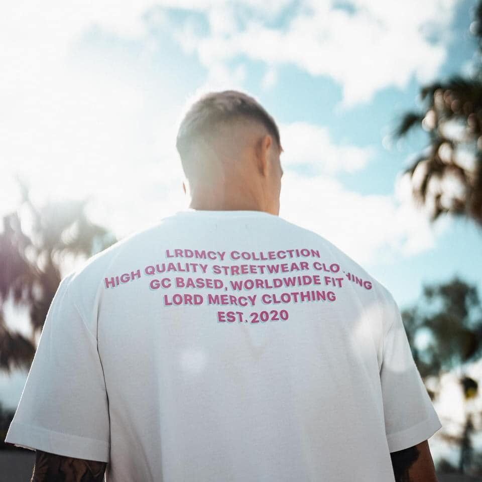 A Man Wearing A White Shirt That Says Lord Mercy Clothing — Carnival Clothing In Miami, QLD