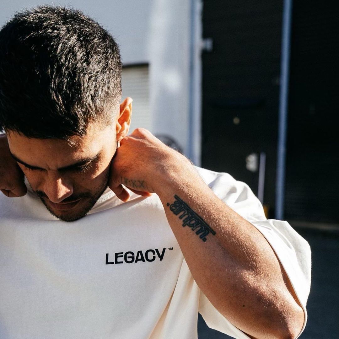 A Man Has A Tattoo On His Arm That Says Legacy — Carnival Clothing In Miami, QLD