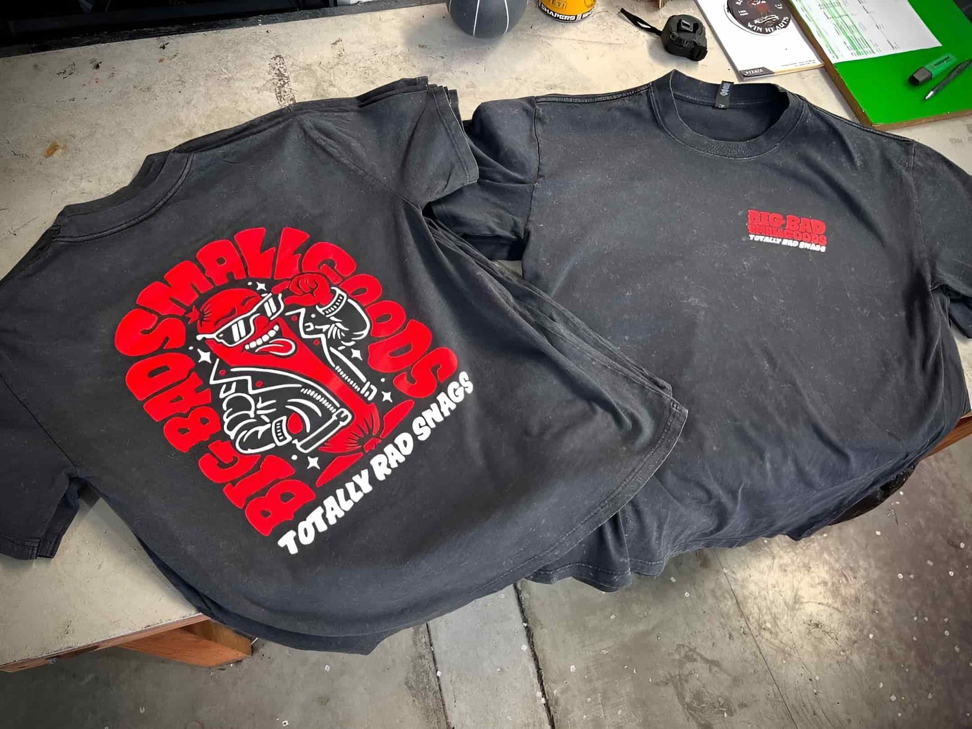 Two T-shirts Are Sitting On A Table And One Says Totally Rid On It — Carnival Clothing In Miami, QLD