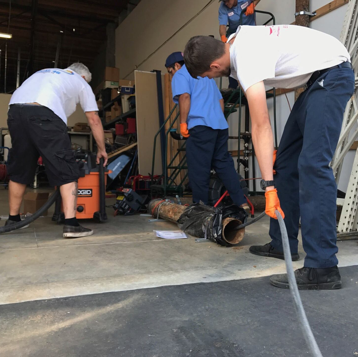 Guys Working On Unclogging Pipe — Ramona, CA — Rooter-Man Plumbers Of San Diego