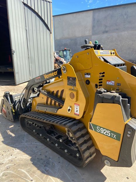 A Yellow Tractor Is Parked In Front Of A Building — Dicko's Bobcat & Tipper in East Bendigo, VIC