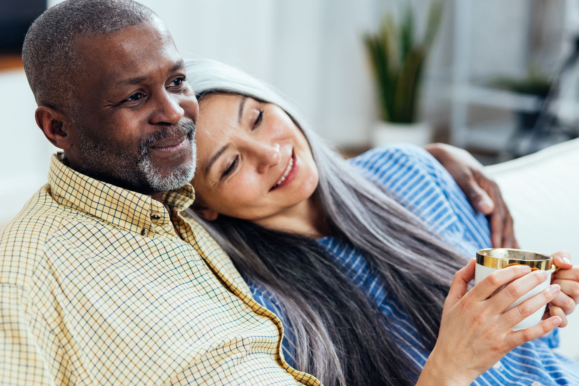 A person is working on an air conditioner with a hose and gauges.