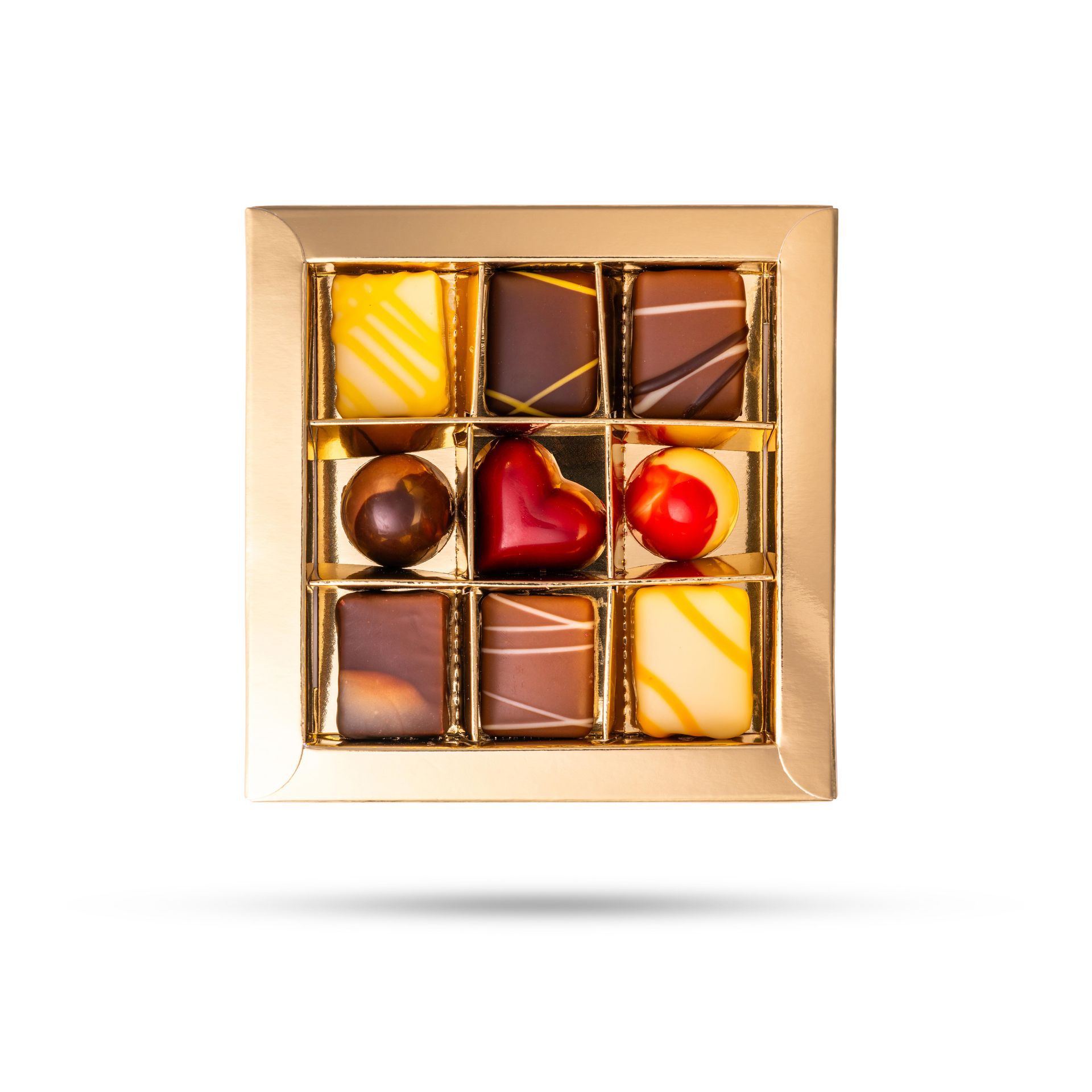 Gouden doos met negen verschillende chocolaatjes, waaronder een hart en andere decoratieve designs.