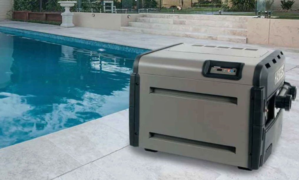 Portable pool vacuum cleaner beside a swimming pool on a tiled deck