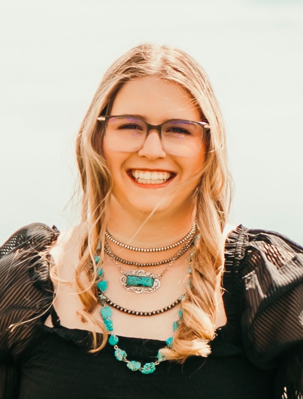 A woman is smiling for a picture in front of a blue background.