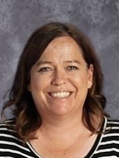 A woman in a striped shirt is smiling for the camera.