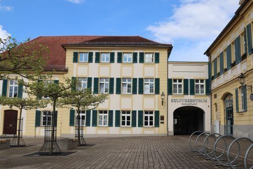 Kulturzentrum Karlsplatz, 3stöckiges historisches Gebäude mit Torbogen