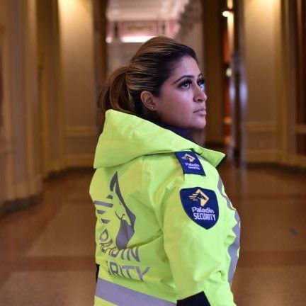 A woman wearing a yellow jacket with the word security on it
