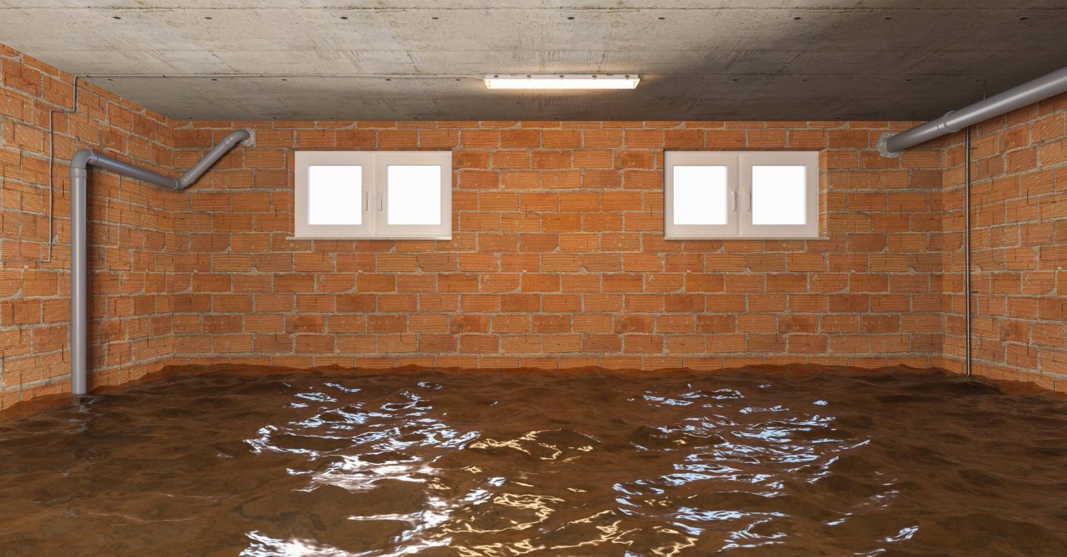 A flooded basement with brick walls and a concrete floor.