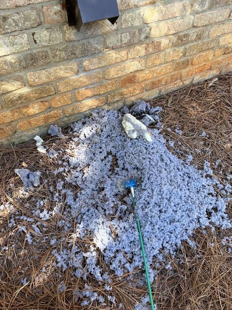 Hand connecting a flexible silver dryer vent hose to a metal vent in a white-painted room.