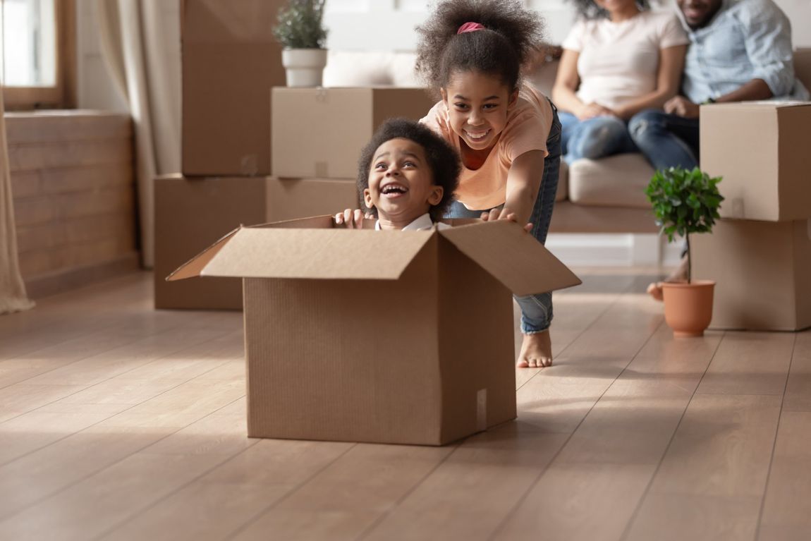 A man and a woman are holding cardboard boxes in front of their faces.