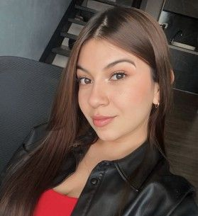 Una mujer con gafas de sol y una camiseta negra sonríe para la cámara