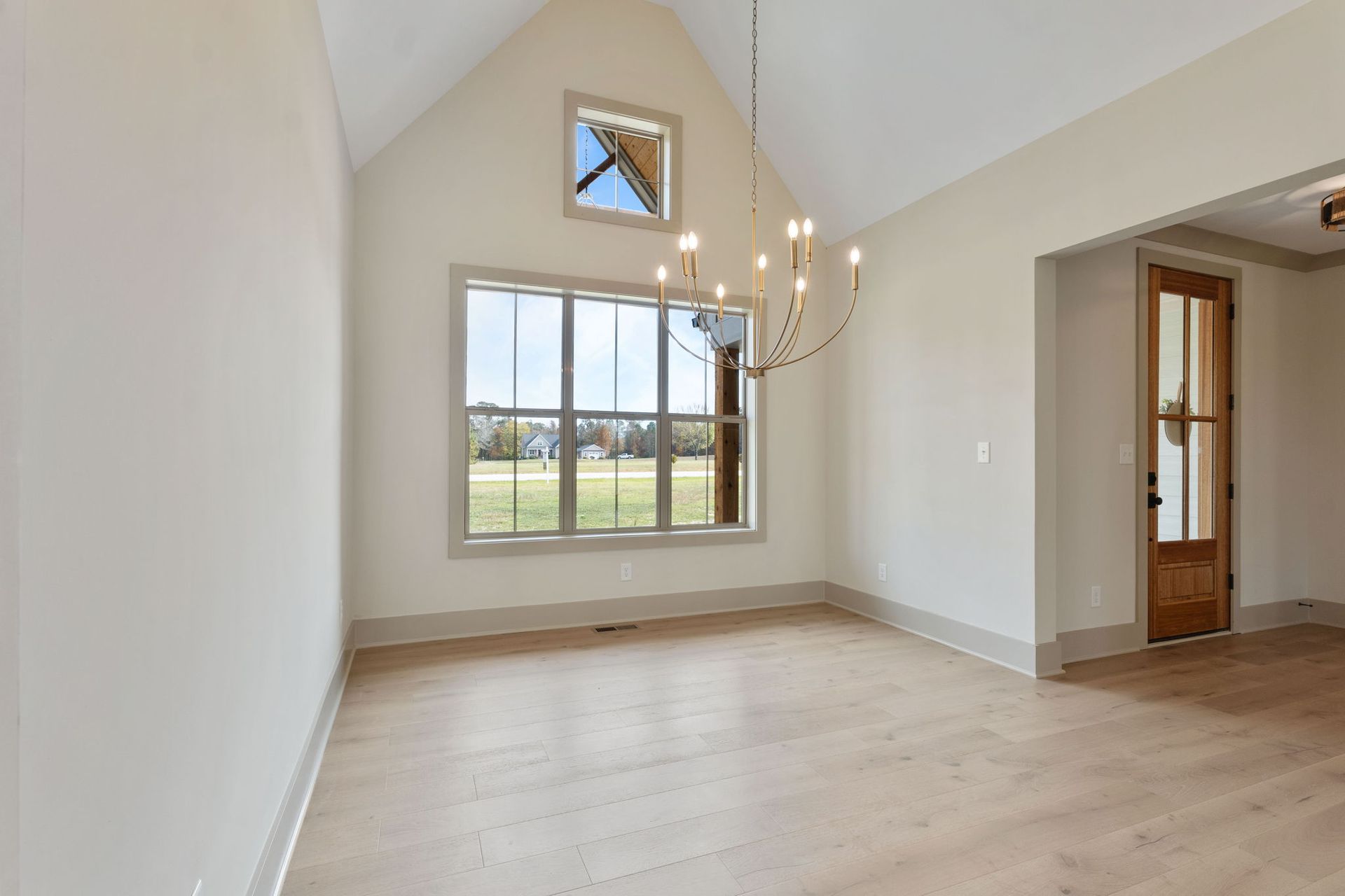 A living room with a vaulted ceiling and a fireplace.