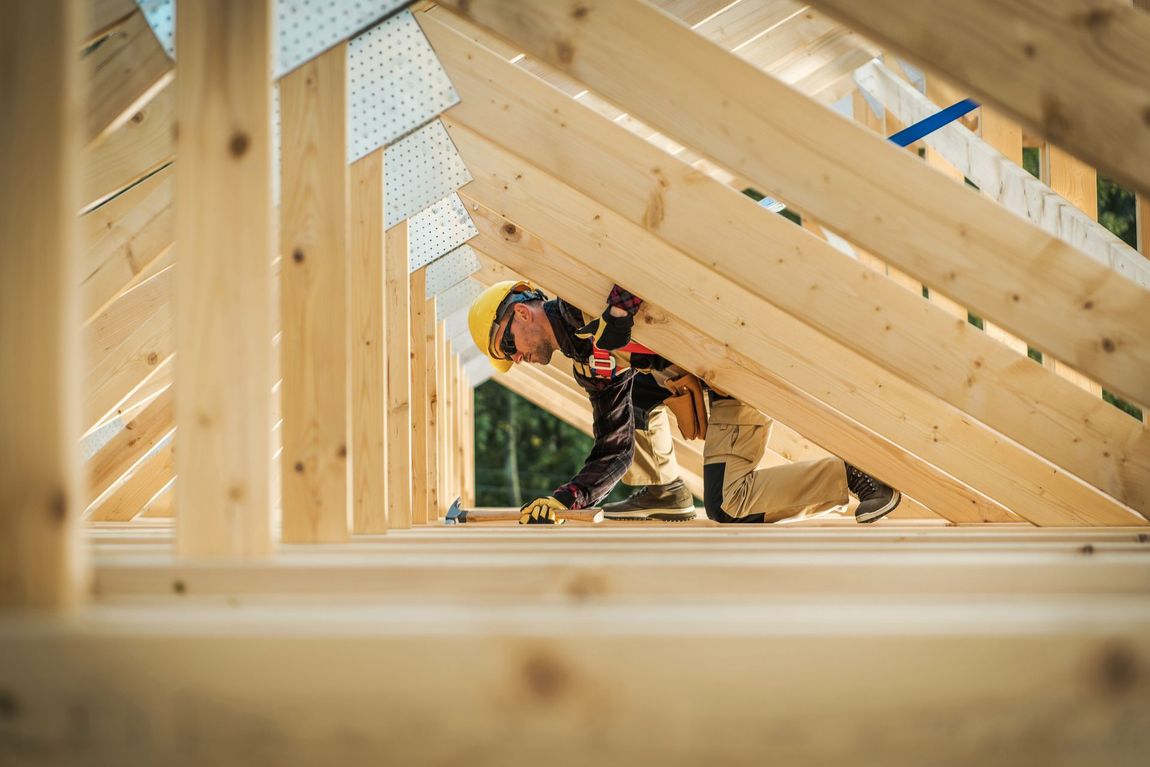 A construction worker is working on a wooden structure.