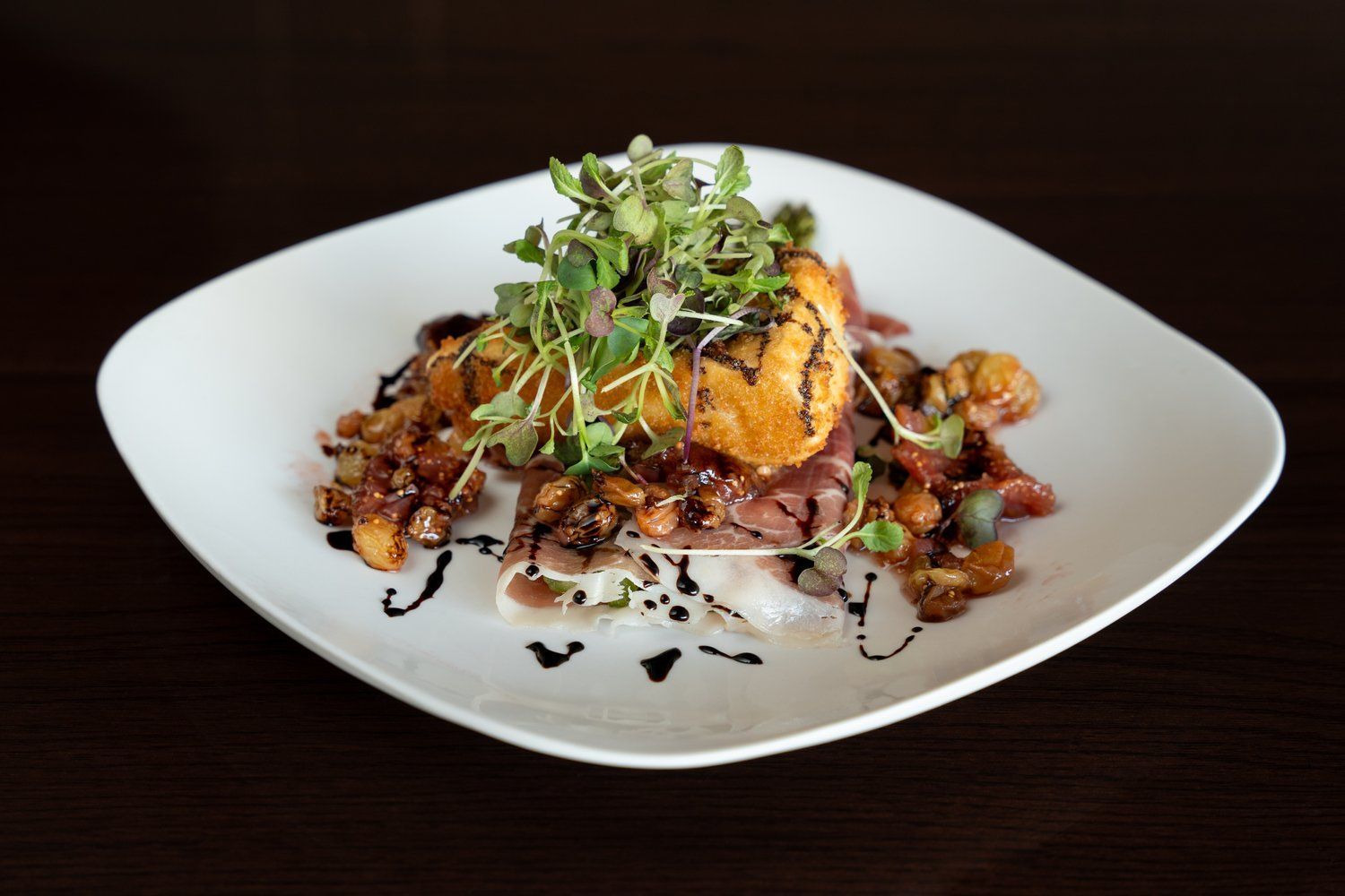 A white plate topped with meat and vegetables on a table.