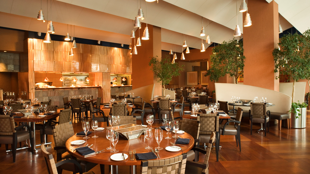 A large dining room with tables and chairs set for dinner