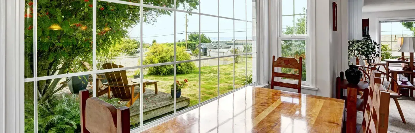 Dining room with clean windows peering into yard