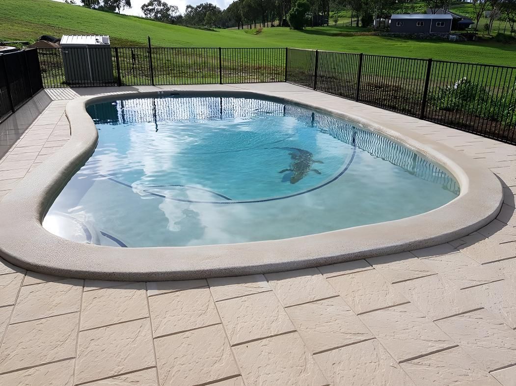 A Large Swimming Pool With A Fence — Doug Allen Pools In Beaconsfield, QLD