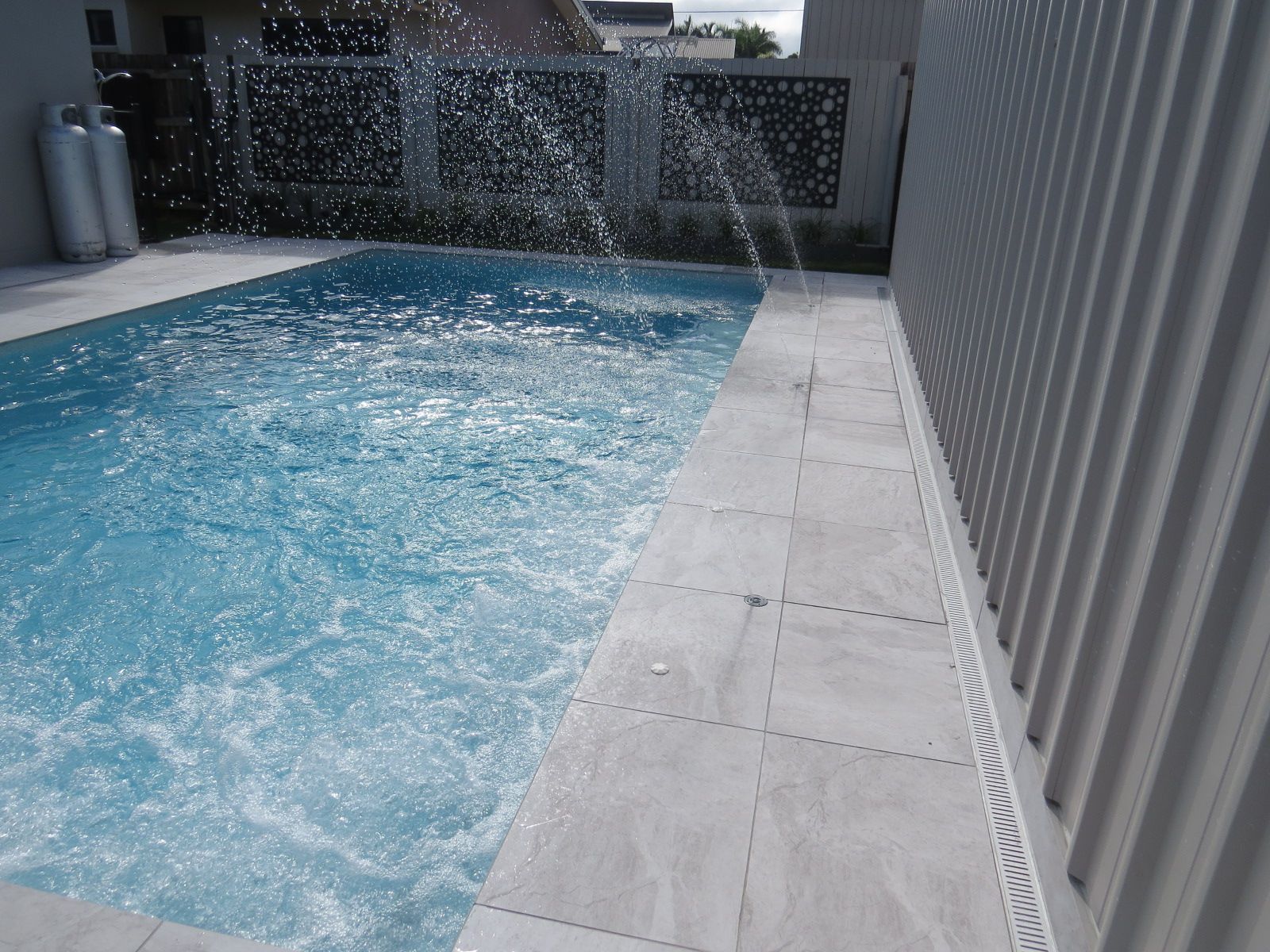 A Large Swimming Pool With Fountains— Doug Allen Pools In Beaconsfield, QLD