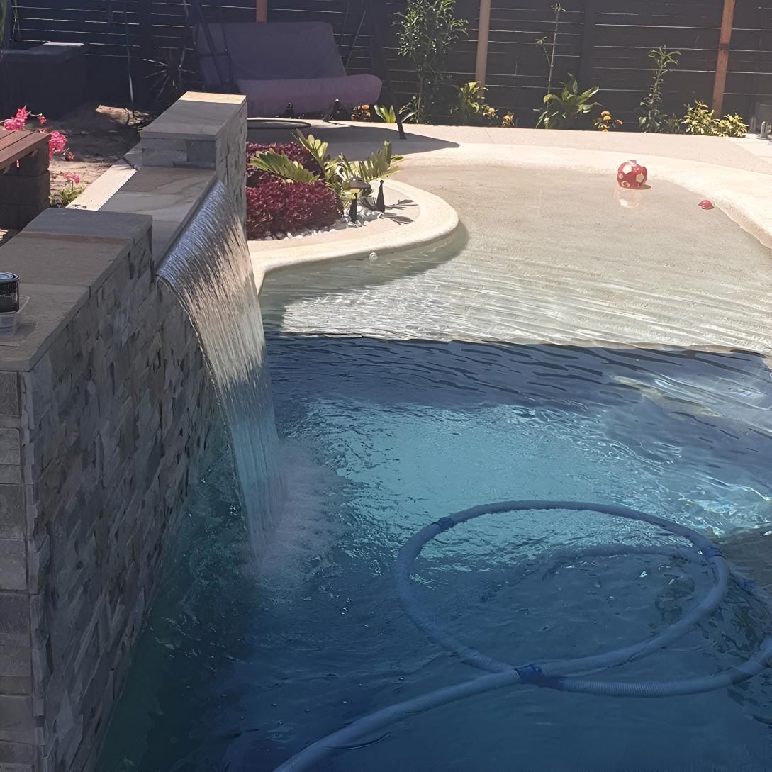 A Large Swimming Pool With A Waterfall — Doug Allen Pools In Beaconsfield, QLD