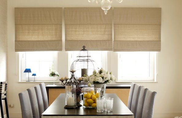 roller blinds hanging over 3 windows in a dining room