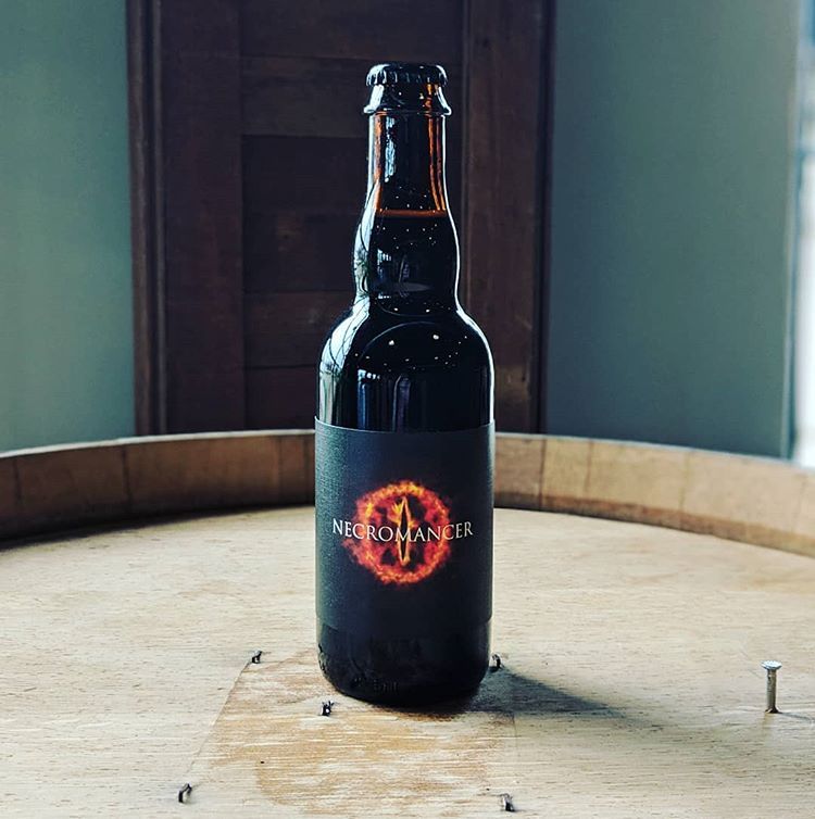 necromancer beer bottle on wooden barrel at White Rooster