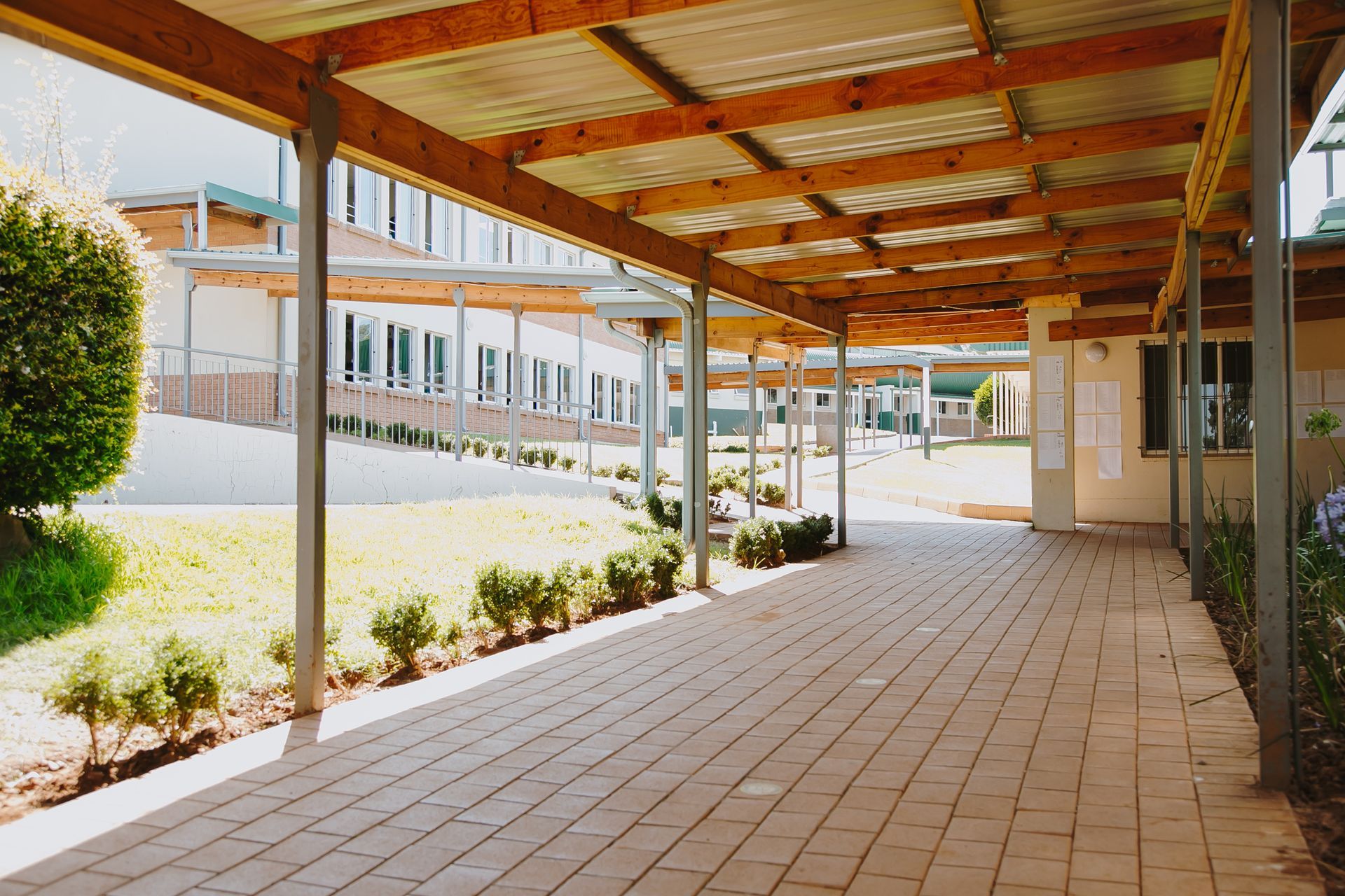A long covered walkway between two buildings with a wooden roof.