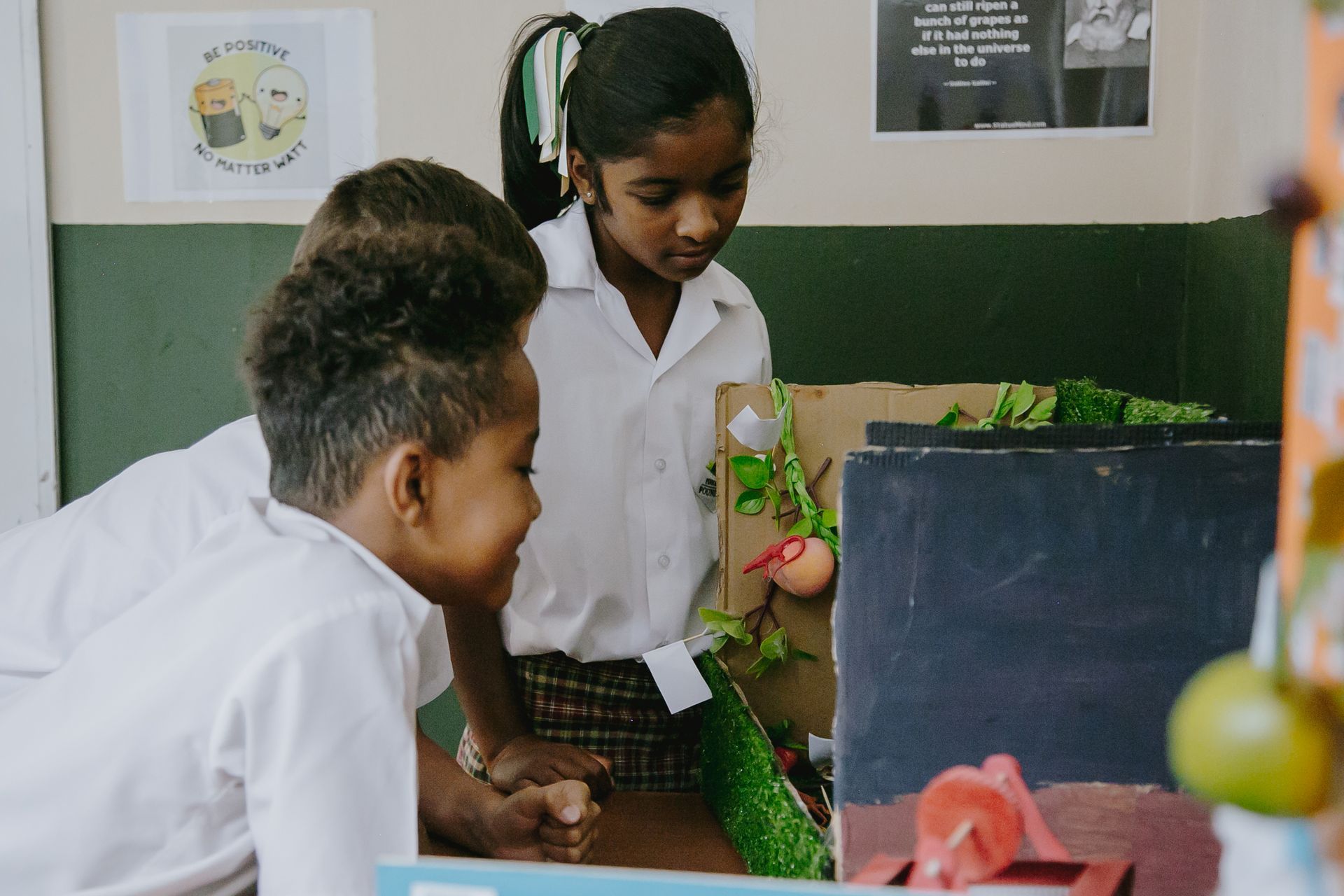 A group of children are looking at a model in a classroom.