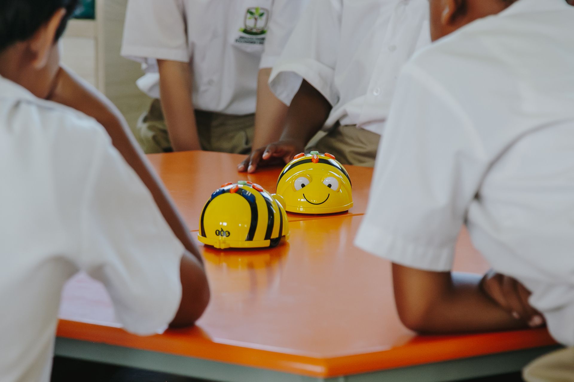 A group of children are sitting at a table with bees on it