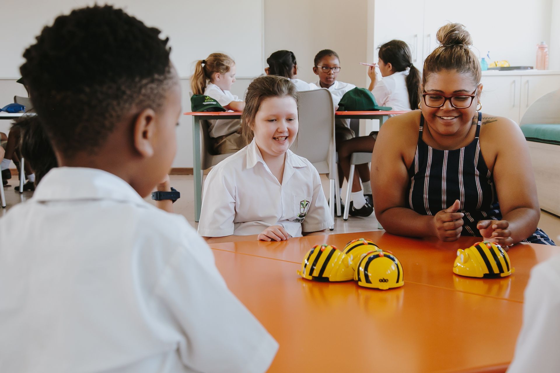 A woman and a boy are sitting at a table in a classroom.