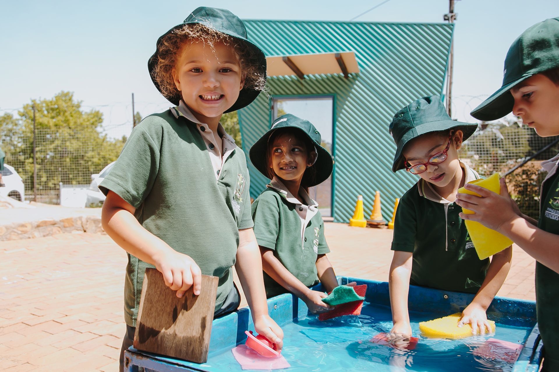 A group of children are playing in a water table.