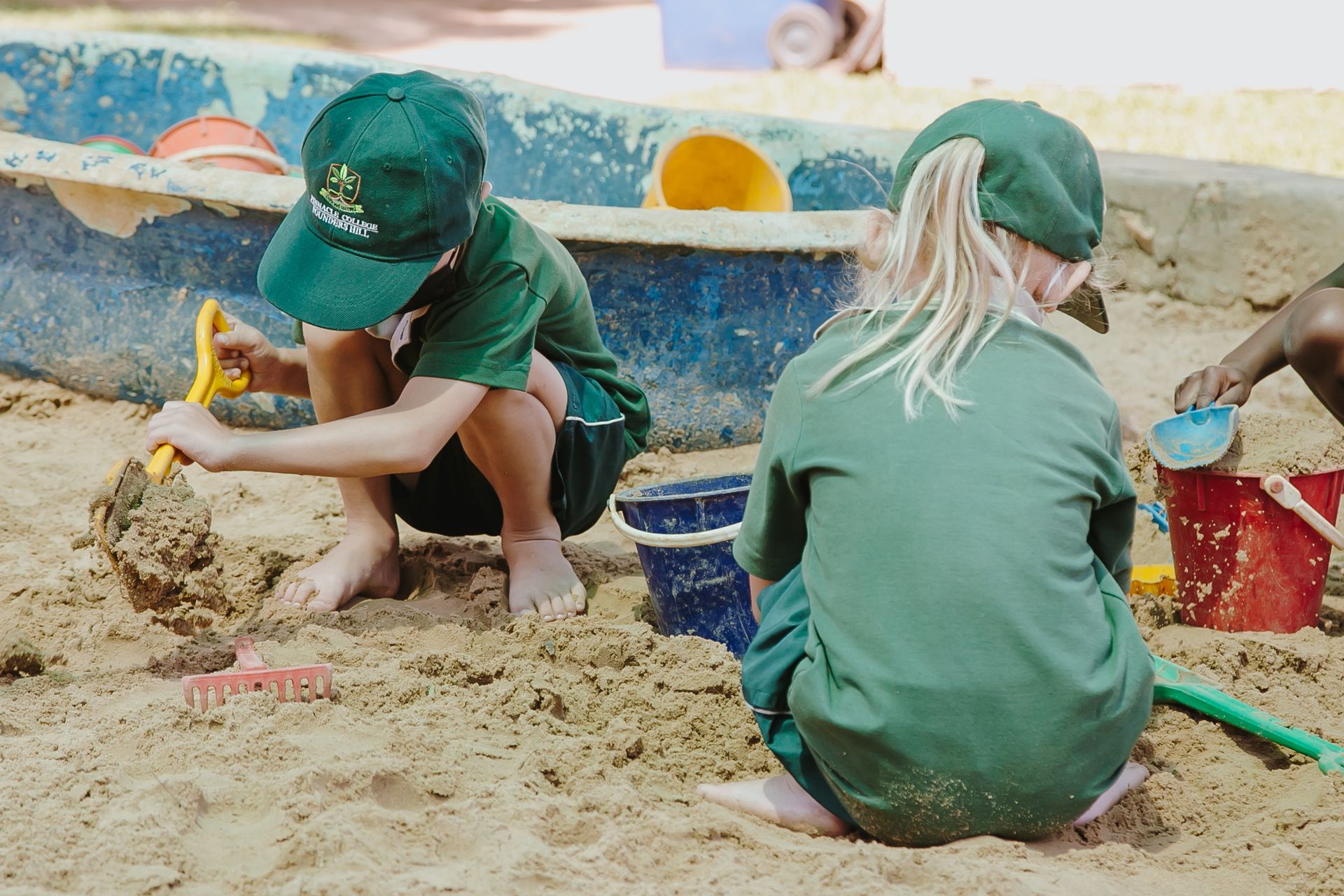 A boy and a girl are playing in the sand