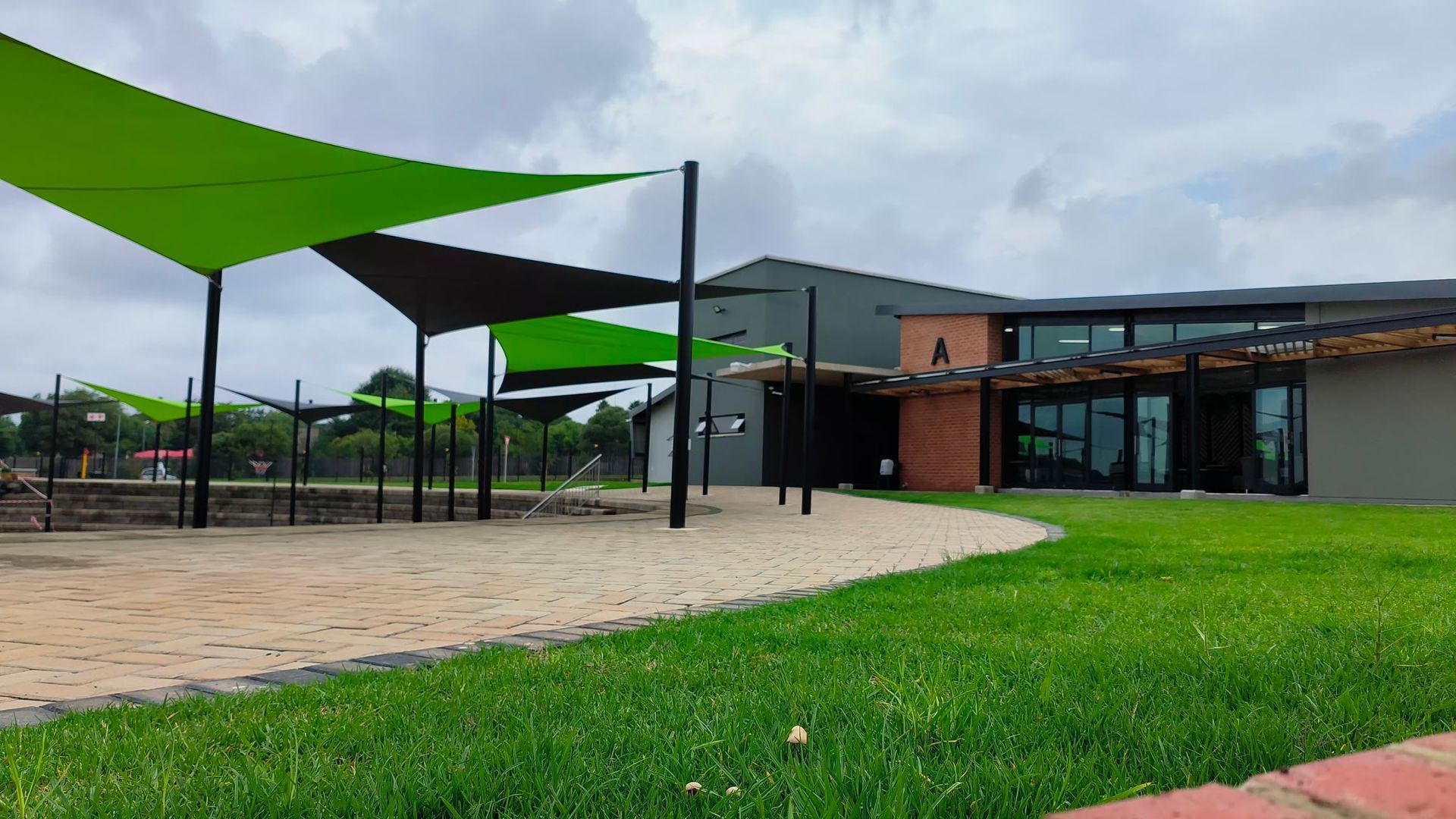 A building with a lot of green umbrellas in front of it.