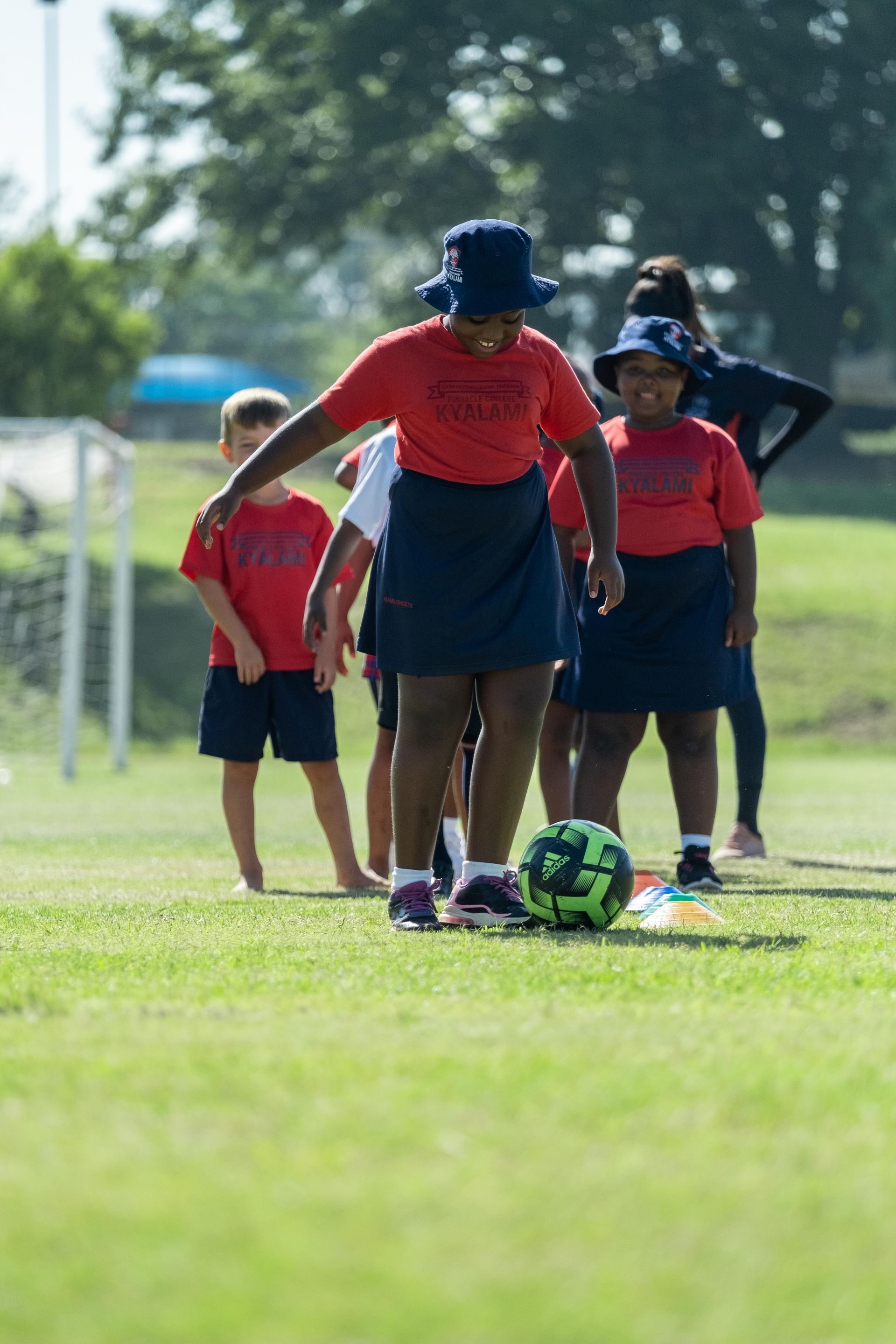 A group of children are playing soccer on a field.